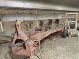 un tracteur qui se trouve dans une grange avec d'autres machines