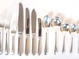 a lot of silver spoons and knives on the table