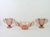 three pink glass vases sitting on top of a white table