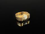 a close up of a gold ring with a diamond on a black surface
