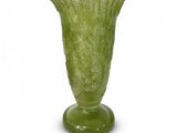 un vase vert posé sur une surface blanche