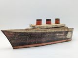wooden model of a large boat with two red and white sails
