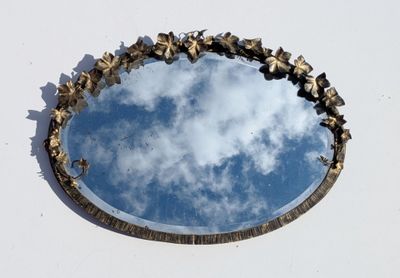 un miroir rond dans lequel se reflète le ciel
