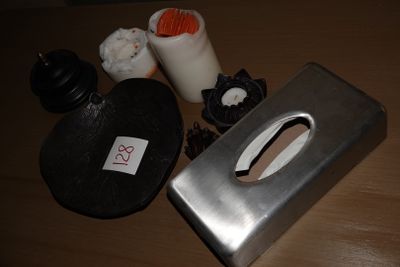 a metal box with a handle and some other items on a table