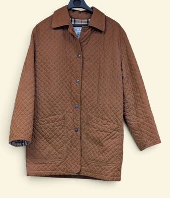 La veste est marron et possède un col à carreaux.