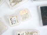 many different types of buttons in plastic containers on a table