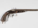 un vieux pistolet avec une poignée en bois sur une surface blanche