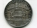 une vieille pièce de monnaie sur laquelle figure l'image d'un groupe de personnes