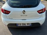 the rear end of a white car parked in a parking lot