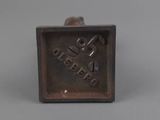 an old metal square shaped object with a bird on it ' s side
