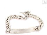 a close up of a silver bracelet with a chain on it