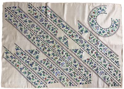 a white table cloth with blue and green designs on it