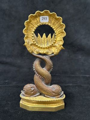 statue en laiton représentant un serpent tenant un coquillage doré, sur fond noir