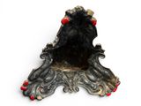 a black and red candle holder on a white surface