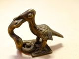une statue en bronze représentant un oiseau tenant un poisson dans son bec