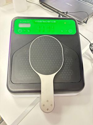 une raquette de tennis posée sur une table, à côté d'un ordinateur portable