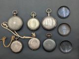 several different types of pocket watches are displayed on a table
