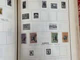 an open book with stamps on it on a table