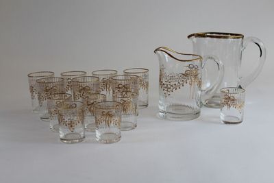 many glasses and a pitcher sitting on a table