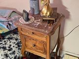 a small table with a lamp on top of it next to a bed