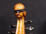 a close up of a violin with a wooden head on it