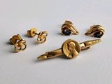 trois paires de boucles d'oreilles dorées et une paire ornée de pierres noires