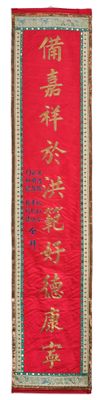 un gros plan sur un tissu rouge orné d'une inscription dorée