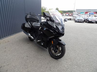 une photo d'une moto noire garée sur un parking