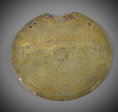 une assiette en or ornée d'un motif sur le devant