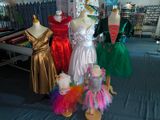 several mannequins and dresses on display in a clothing store