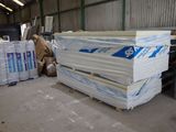 a large stack of white plastic sheets in a warehouse