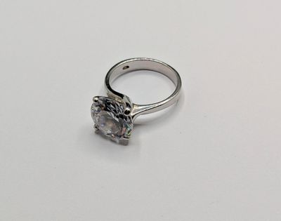 une image d'une bague en diamant sur une surface blanche