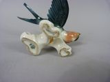 porcelain figurine of a bird with a flower in its beak