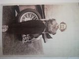 a black and white photo of a woman standing in front of a car