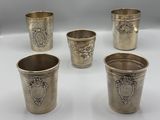 quatre coupes en argent ornées de motifs, posées sur une table