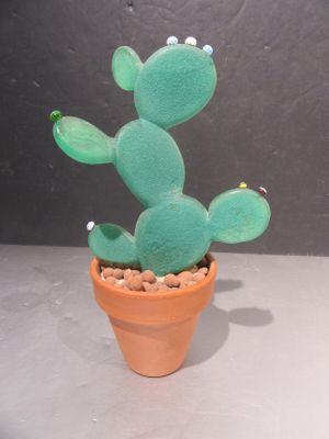 un petit cactus vert dans un pot en terre cuite, sur lequel sont dessinés des yeux
