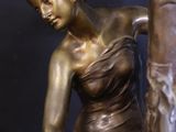 bronze statue of a woman with a horse on a black background