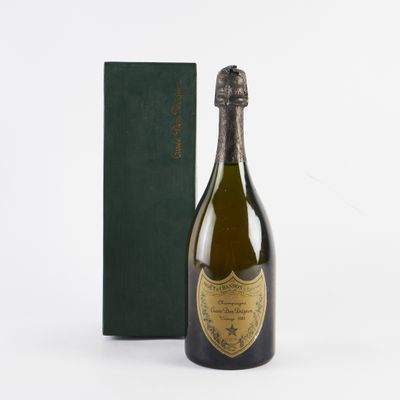 La bouteille de champagne se trouve à côté d'une boîte verte, posée sur une surface blanche.
