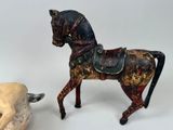 a statue of a horse with a saddle next to a rock