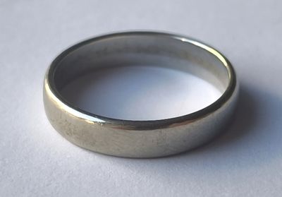a silver ring sitting on a white surface