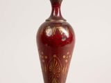 a close up of a red vase on a table