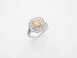 une bague sertie d'un diamant jaune et blanc sur fond blanc