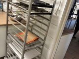 a metal rack with trays on top of it in a kitchen