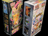 two boxes of pokemon cards sitting next to each other