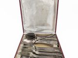 an open box with silverware in it on a white surface
