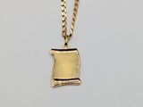 a gold plated necklace with a small piece of paper on it