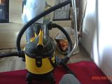 a yellow and black vacuum sitting on a red rug