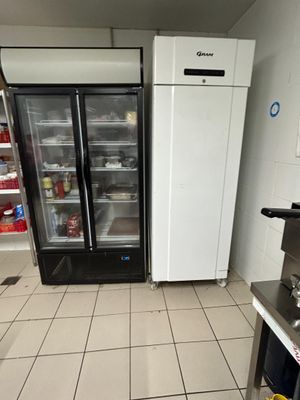 two refrigerators that are in a kitchen next to each other