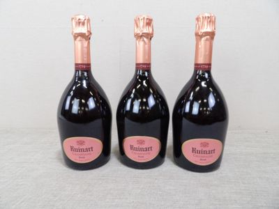 trois bouteilles de champagne posées les unes à côté des autres sur une table