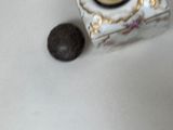 a small vase and a ball on a white table